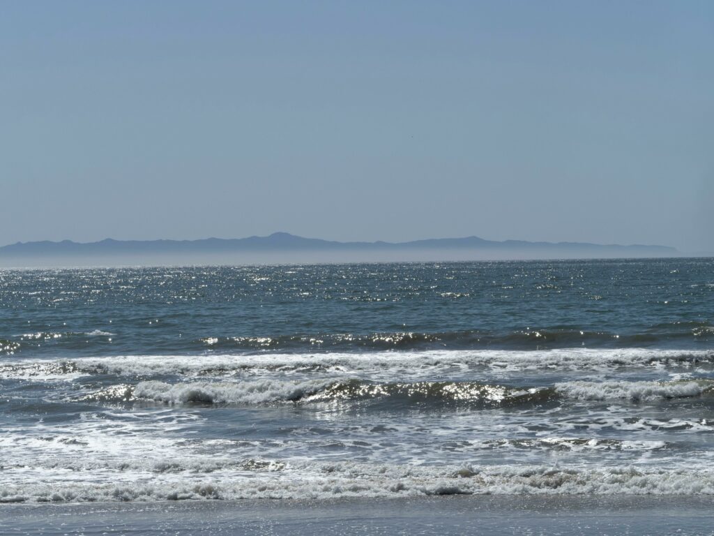 Serene summer seascape with waves crashing on San Diego beach, California.